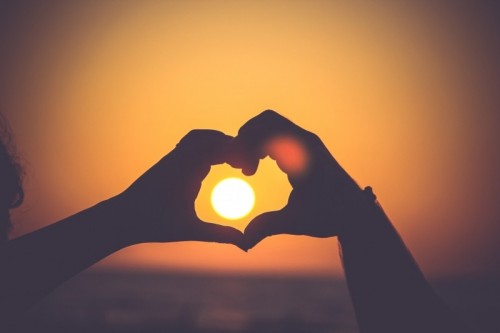 sunset-seen-through-hands-in-heart-shape