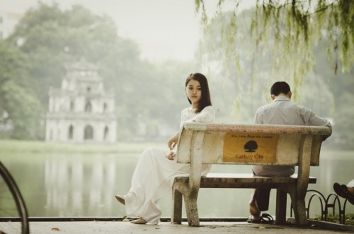 young-couple-sitting-on-bench-in-park-1