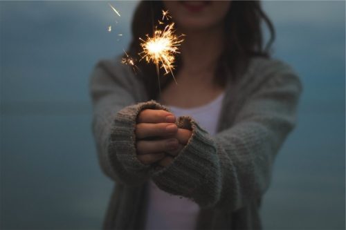 young-woman-holding-sparkler-at-night